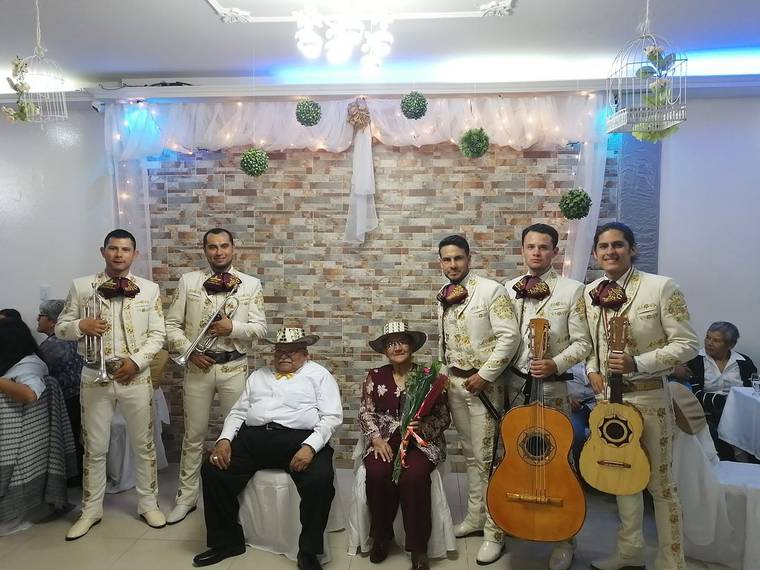 Mariachi juvenil cantando a una pareja de esposos en la celebración de su aniversario en Bogotá