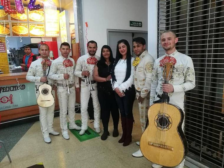 Mariachi juvenil posando con las clientas después de una serenata sorpresa en Bogotá