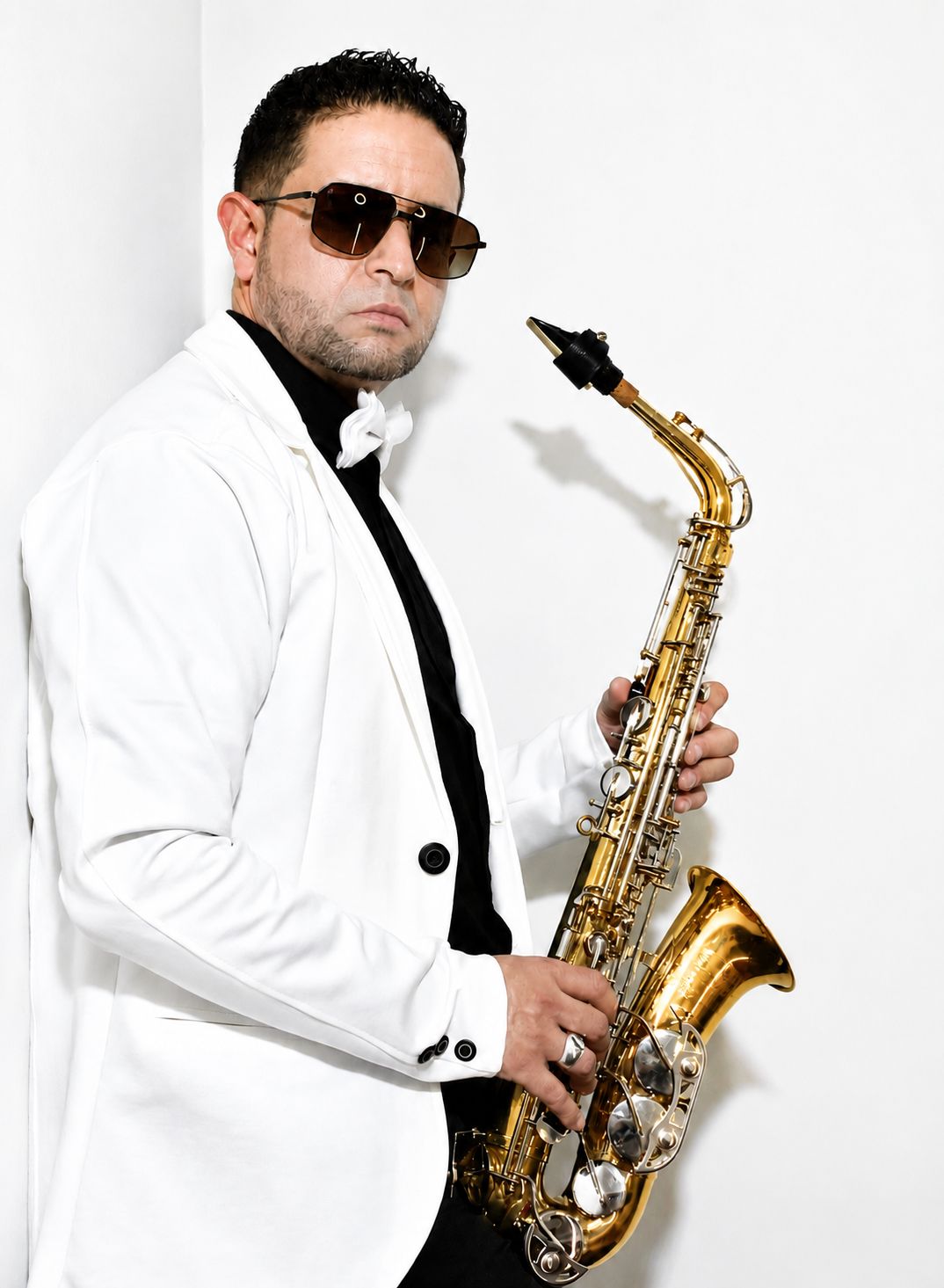 Saxofonista en Bogotá con esmoquin blanco y saxofón alto dorado para bodas exclusivas