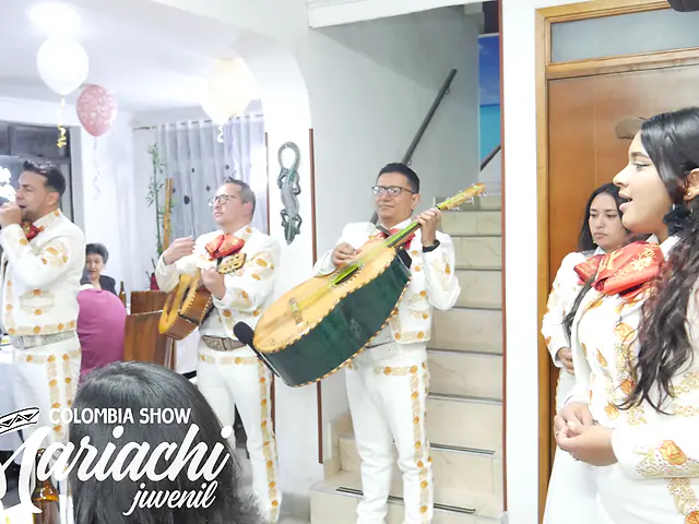 Serenata de mariachi dentro de una casa en Bogotá con la homenajeada cantando